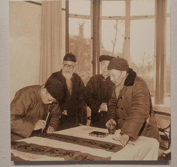 展览资料图，摄于1960年，时沈尹默在写春联，旁长髯者为黄葆戉