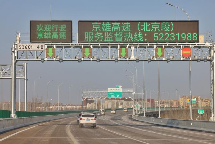 12月27日,驾车在京雄高速上行驶,不错看到许多的可变信息板,能知道出刻下车说念的通行情况。 新京报记者 王贵彬 摄