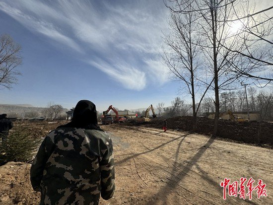 　　12月25日，金田村一位村民站在路边一直看着自家的房子被救援人员一点点挖出来，她说：里面存着一家几口人的粮食。中青报·中青网见习记者&nbsp;赵丽梅/摄