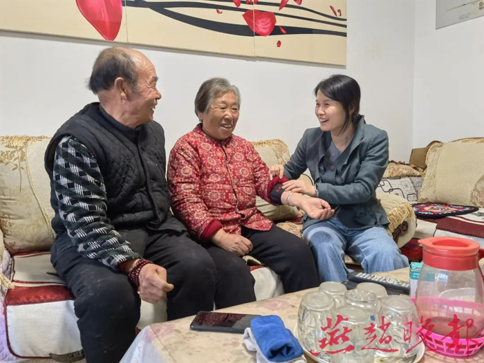 文然然（右一）在询问胡喜爱（中）的身体情况。