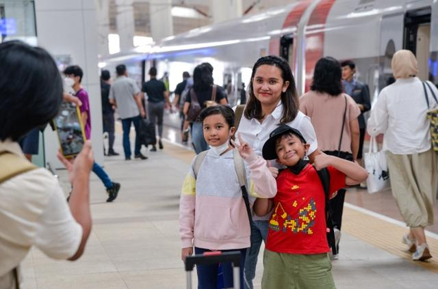 12月25日，乘客在印度尼西亚雅加达哈利姆站站台和雅万高铁高速动车组合影。新华社 图