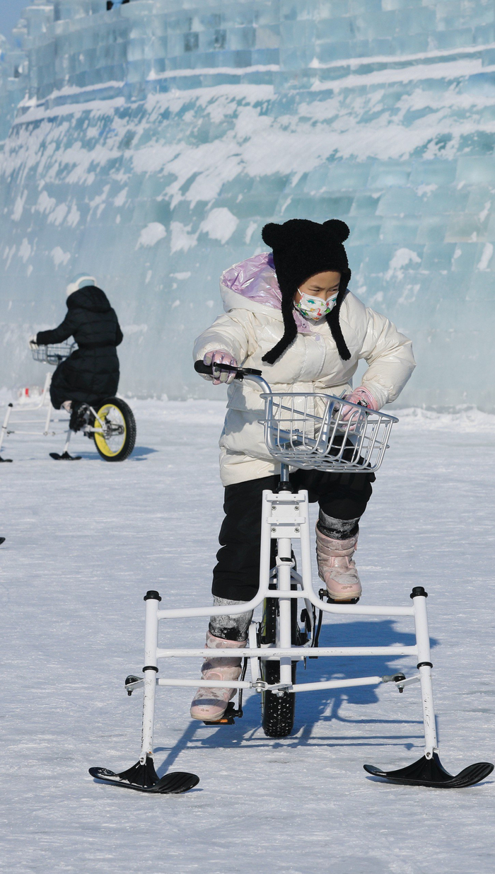 2023年12月31日，哈尔滨，游客在冰雪大世界园区游玩打卡。IC photo 图