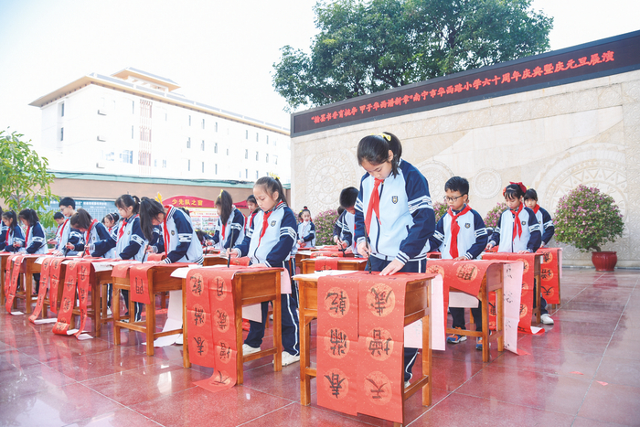     南宁市华西路小学三、四年级学生书写春联。    本报记者黄红锦 摄