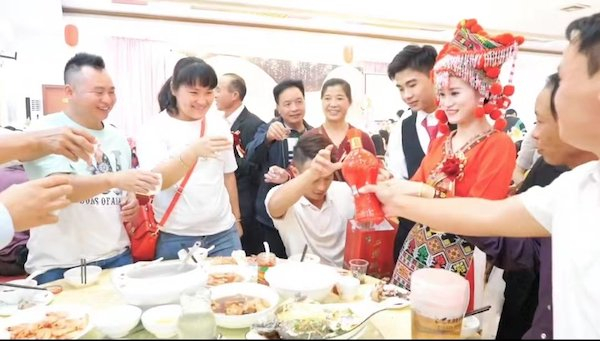 贵平与新娘在婚宴上敬酒，新娘是瑶族姑娘，身着瑶族新娘服饰，2022.10