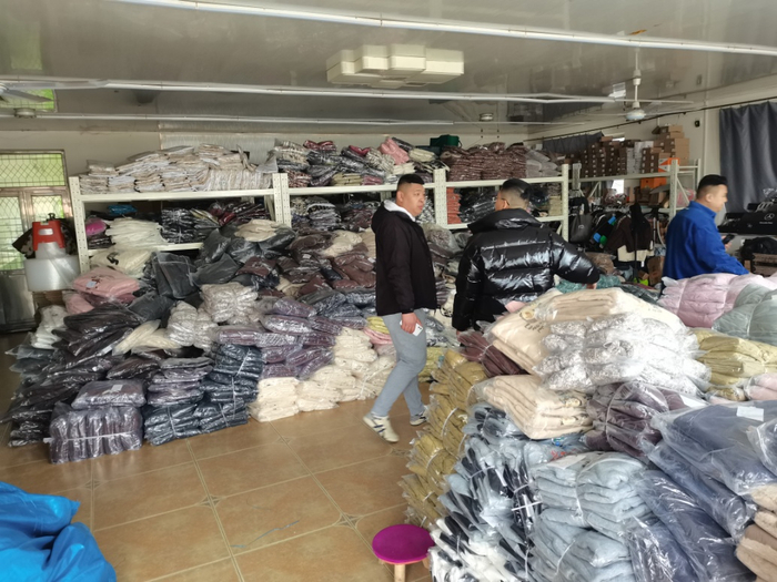 图为车间内现场查获的假冒品牌服装。