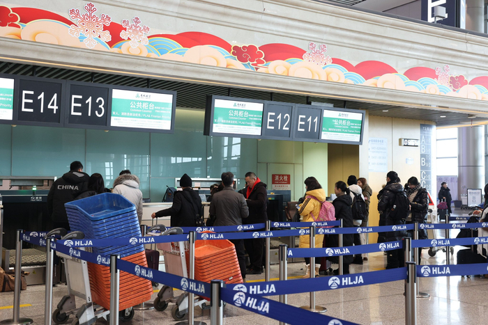 旅客办理登机手续。哈尔滨机场供图