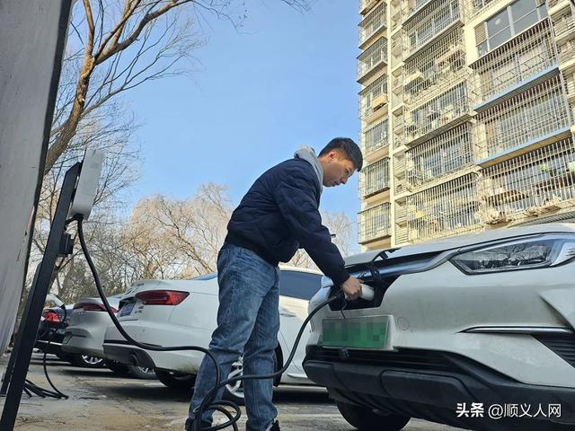 在望泉西里二區南側停車場,一輛輛新能源汽車正整齊地停靠在充電樁前