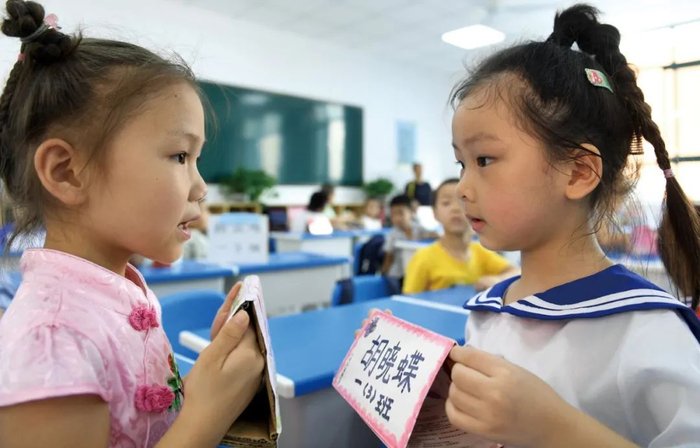 〓 2020年9月1日，安徽六安。两名小学新生在相互介绍自己的姓名。（图/视觉中国）