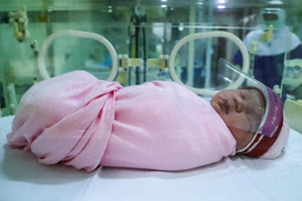 2020年4月17日，在印度尼西亚雅加达，一名刚出生的宝宝佩戴防护面罩。图源：新华社