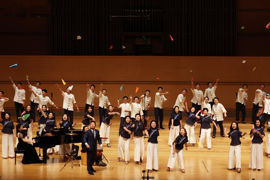     1月7日晚，演出现场，越人合唱团团员向台下放飞纸飞机。广西文化艺术中心供图