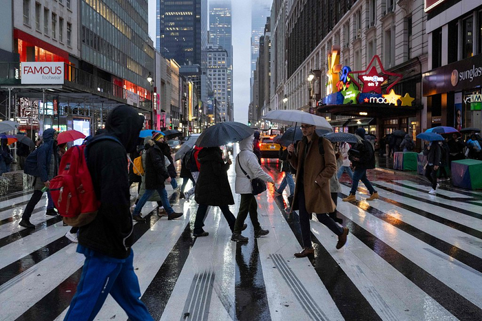 当地时间2024年1月9日，美国纽约，人们打着伞在暴雨中行走。