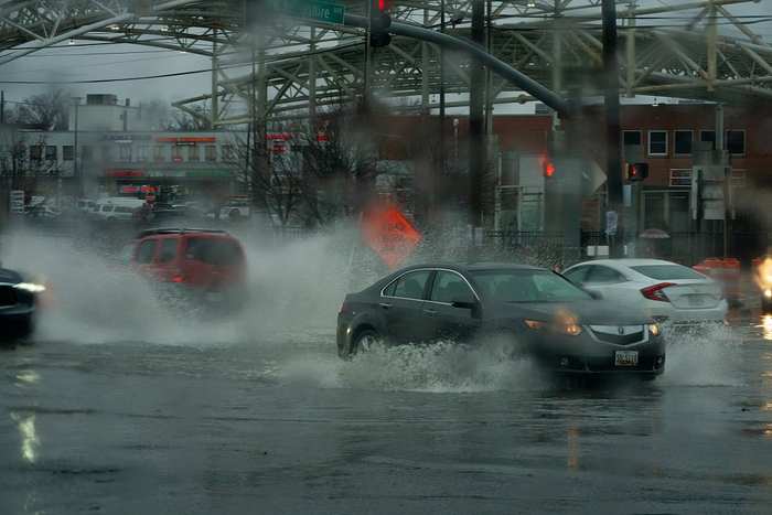当地时间2024年1月9日，美国马里兰州受洪灾影响，汽车穿过积水的街道。