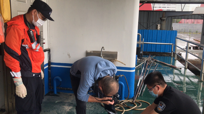 李富瑶（中）和陆韵清（右）在公安码头对浮尸进行初步勘验。受访者供图