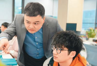 匡明（左）与团队成员在分析系统数据。受访者供图