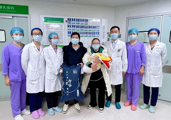 何女士和丈夫抱着女儿出院