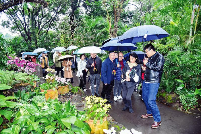     嘉宾们参观青秀山风景区，用手机记录兰园美景。本报记者黄红锦  摄