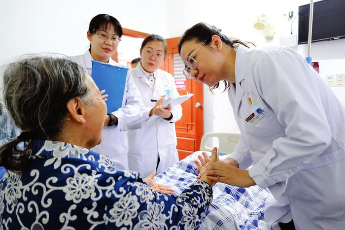 南宁市中医医院老年病科副主任马宁宁（右）进行查房，了解患者的病情和身体变化情况。 本报记者宋延康 摄