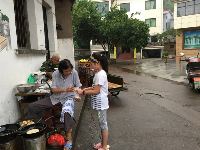 ▲2017年，毛师花在桥头一处屋檐下卖早餐。受访者供图