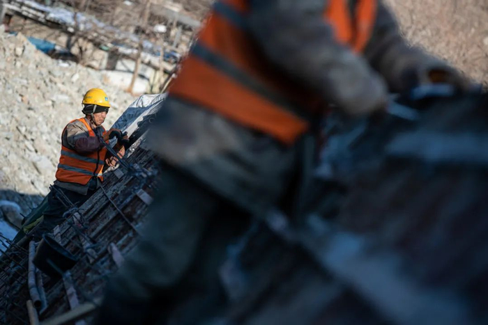 2024年1月3日，房山区，建筑工人正在双泉河修筑堤坝。