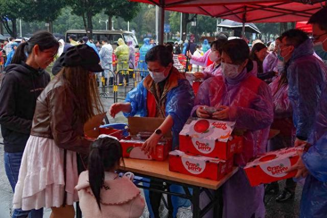 2024年1月11日，南宁，在“三街两巷”历史文化街区，市民在领取黑龙江省抚远市的蔓越莓鲜果。视觉中国供图