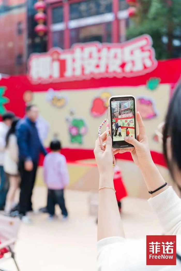 年轻人打卡游戏区“椰门投投乐”，接好运、收获快乐。（图/菲诺供图）