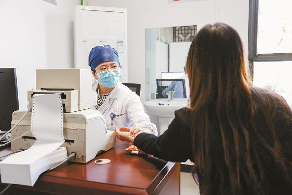 松江区泖港镇社区卫生服务中心，医生在为市民把脉问诊  姜辉辉  摄