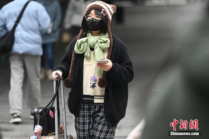 1月23日,受强冷空气影响,广东省广州市出现降温天气,出行市民添加衣服