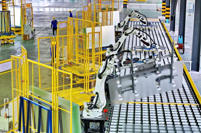 2023年10月25日，江西省赣州市定南县的一家专精特新企业智能车间，工人在自动化生产线上加工光伏玻璃