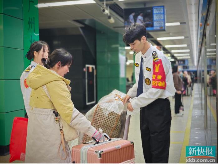 地鐵安檢員幫助乘客據統計,春運首日,廣州地鐵線網客流量最高為三號