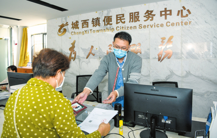 在城西镇便民服务中心，市民为家人申领重度残疾人护理补贴。记者 康登淋 摄