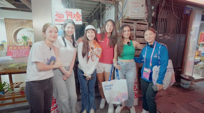 郑钦文在杭州亚运会期间带外国友人逛街。