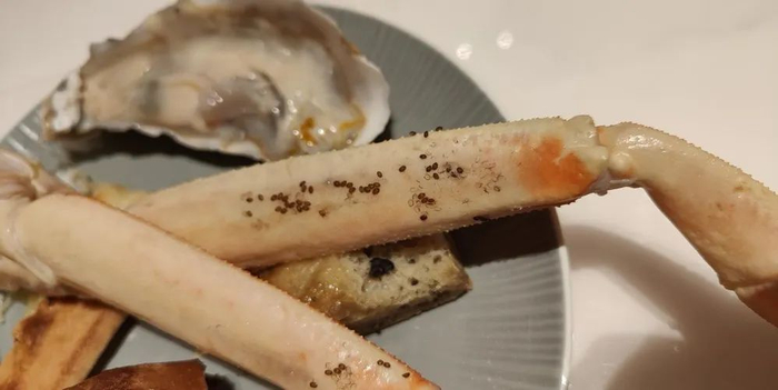 程女士提供的图片显示，煮熟的蟹腿上有许多黑色不明颗粒