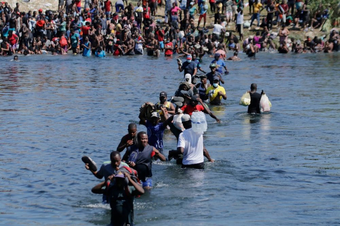  2021年9月19日，从美墨边境墨西哥科阿韦拉州阿库尼亚城一侧拍摄的照片显示，购买物资的非法移民在里奥格兰德河上往返。新华社发