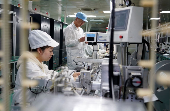 2023年12月21日，浙江温州，在位于乐清市的浙江宝龙机电有限公司微型马达生产车间，工人在生产线上忙碌。视觉中国 图