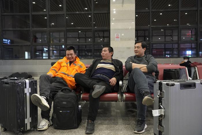 1月27日凌晨，在乌兹别克斯坦务工的秦松、何天、郭文志（从左至右）乘坐飞机回国后，到北京西站中转。  新京报记者 赵敏 摄