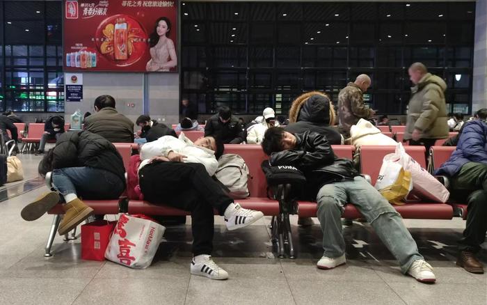 凌晨的北京西站，候车的三位乘客在座椅上睡着了。  新京报记者 赵敏 摄