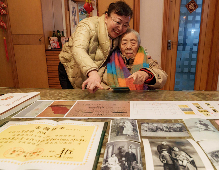 ▲2月5日，肖鸣锵家中，肖鸣锵（右）和女儿崔健（左）展示捐赠的文物清单和证书。见习记者 李雨恒 摄