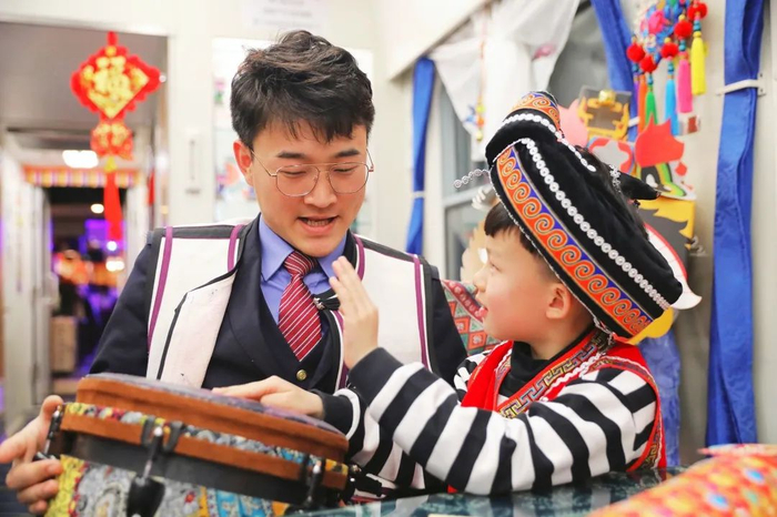 乘务员邀请小乘客体验民族乐器。图源：“中国铁路”微信公众号