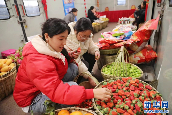 2月2日，“慢火车”年货街上，乘客正在挑选水果。图源：新华网（杨紫轩 摄）