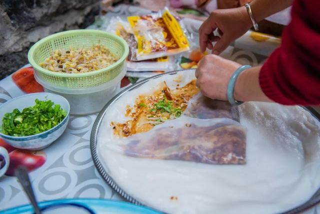 薄如蝉翼的卷粉皮包上米线,黄瓜等丰富配料,沾上些许辣椒油,咬一口