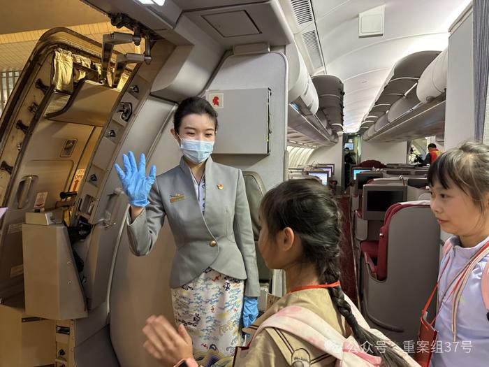 飞机落地，屈芮芮在客舱门口和小旅客挥手告别。&nbsp; 新京报记者 陶冉 摄