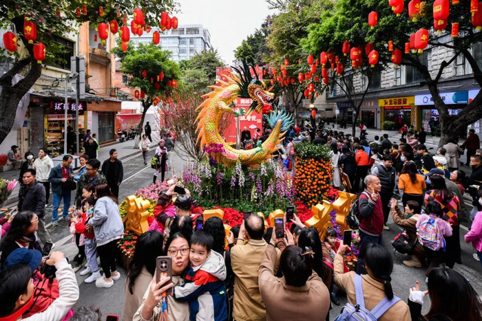 市民在2024越秀西湖花市位于教育路的花坛前合照留念。信息时报记者 胡瀛斌 摄