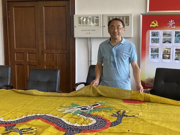 这面龙旗上缘有一排便于悬挂的铜扣眼