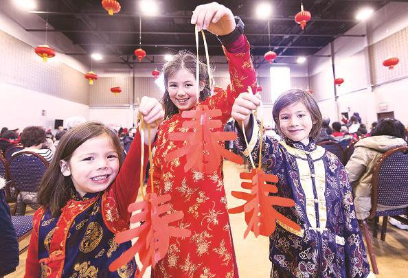             在加拿大多伦多，身穿中国传统服饰的儿童展示剪纸作品          