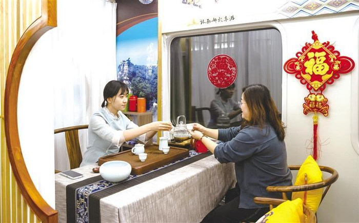     旅客在旅游专列的茶室内品茶  □铁路局供图
