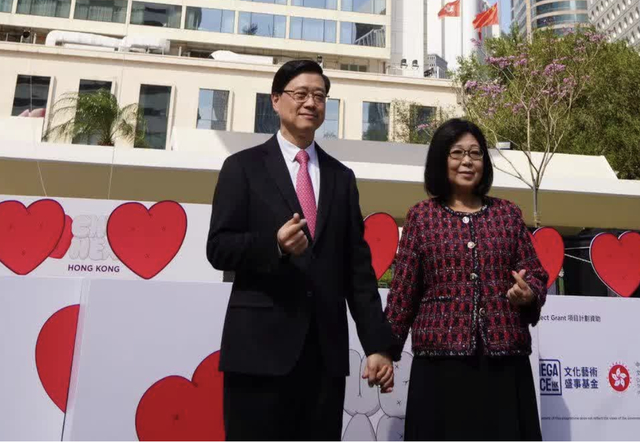 14日，李家超和太太“比心”打卡 图自香港点新闻