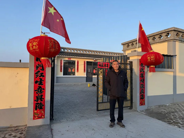 ▲村民在新房院门口贴对联，挂红灯笼，喜庆迎新年。新京报记者 乔迟 摄