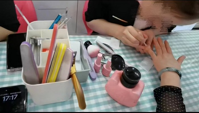 图/玲玲在店里为顾客做指甲，来源/玲玲供图