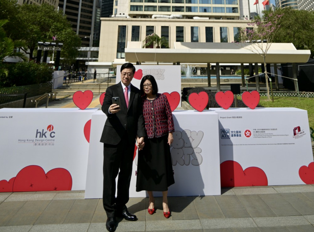 14日，李家超拿起手机与夫人李林丽婵自拍 图自 香港星岛网