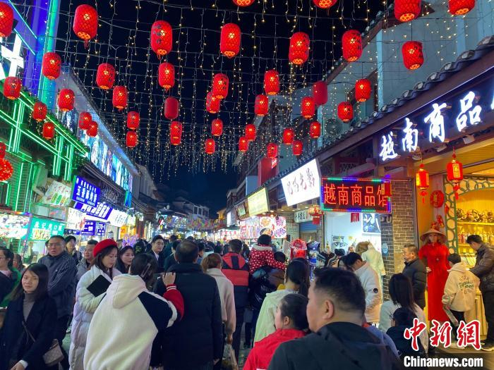 图为2月10日晚,广西桂林阳朔西街吸引众多游客游览购物.
